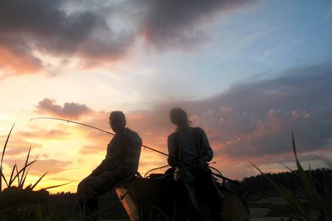 Рыбаки в лодке на закате